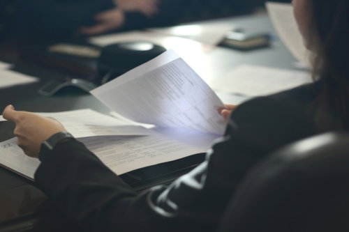 a-woman-sitting-at-a-table-reading-a-paper.jpg a woman sitting at a table reading a paper